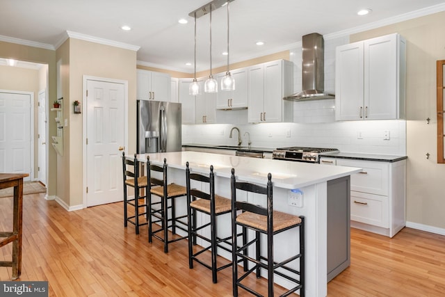 285 Cherry Ln, Kennett Square, PA 19348 - kitchen featuring wall chimney range hood, a breakfast bar area, stainless steel appliances, light wood-style flooring, and baseboards