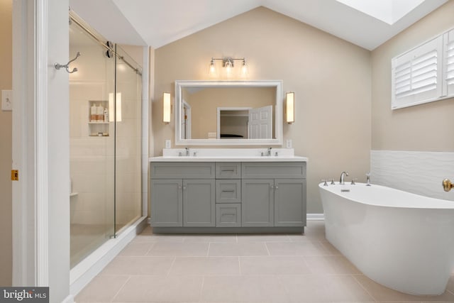285 Cherry Ln, Kennett Square, PA 19348 - full bathroom with tile patterned flooring, double vanity, a freestanding tub, a shower stall, and vaulted ceiling