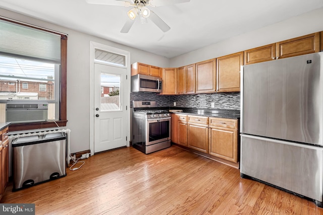 434 Elrino St, Baltimore, MD 21224 - kitchen featuring appliances with stainless steel finishes, light wood-style floors, cooling unit, a ceiling fan, and backsplash
