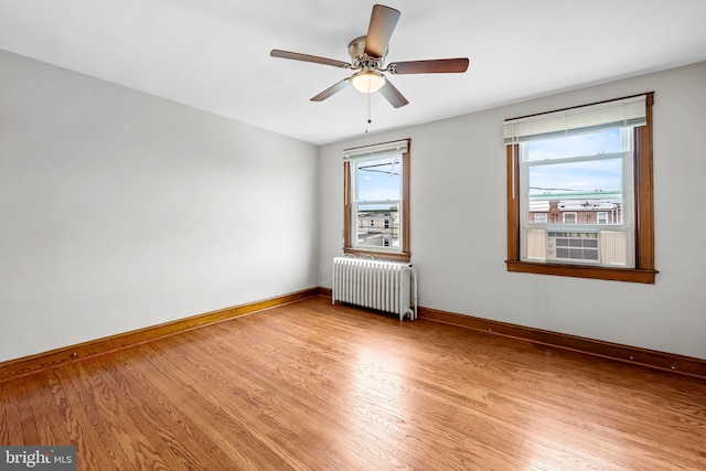 434 Elrino St, Baltimore, MD 21224 - empty room with radiator heating unit, light wood-type flooring, baseboards, and plenty of natural light