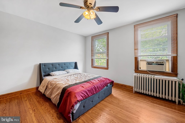 434 Elrino St, Baltimore, MD 21224 - bedroom with radiator heating unit, baseboards, wood finished floors, ceiling fan, and cooling unit