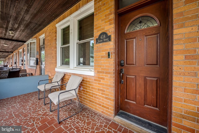 434 Elrino St, Baltimore, MD 21224 - doorway to property featuring a porch and brick siding