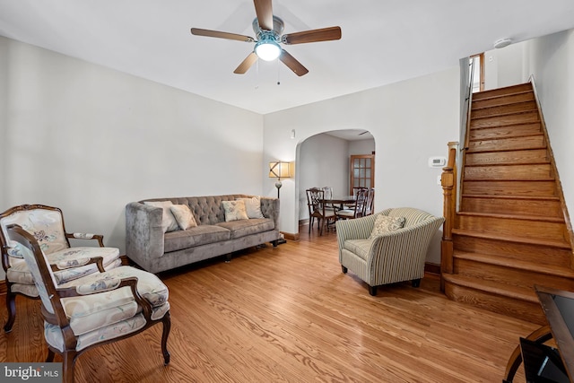 434 Elrino St, Baltimore, MD 21224 - living room featuring arched walkways, a ceiling fan, stairs, and light wood-type flooring