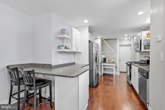 154 Mercy St, Philadelphia, PA 19148 - kitchen featuring stainless steel appliances, open shelves, dark countertops, white cabinets, and dark wood-type flooring
