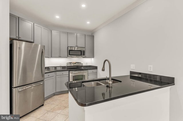 1391 Pennsylvania Ave SE Unit 348, Washington, DC 20003 - kitchen with appliances with stainless steel finishes, a sink, a peninsula, dark countertops, and ornamental molding