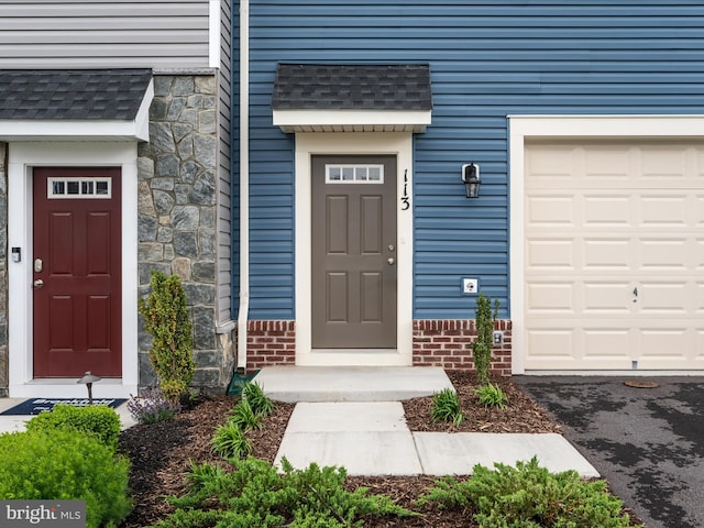 113 Heyford Dr, Stephenson, VA 22656 - view of exterior entry with a garage and a shingled roof