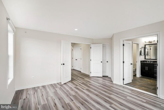 22635 Naugatuck Sq, Ashburn, VA 20148 - unfurnished bedroom featuring baseboards, wood finished floors, recessed lighting, ensuite bath, and a sink