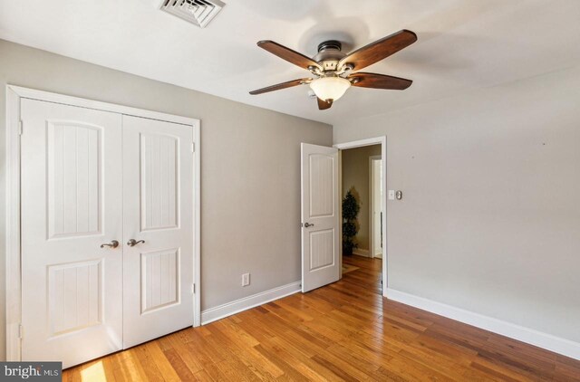 2218 Oakwood Ln, Atco, NJ 08004 - unfurnished bedroom with a closet, baseboards, light wood-type flooring, and ceiling fan