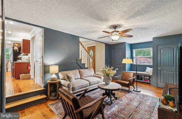 2218 Oakwood Ln, Atco, NJ 08004 - living room with a ceiling fan, stairs, wood finished floors, baseboards, and a textured ceiling