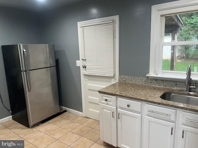 3403 Murdock Rd, Kensington, MD 20895 - kitchen featuring freestanding refrigerator, a sink, white cabinets, light tile patterned floors, and dark stone counters