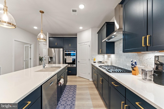 6411 Tulip Ter, Haymarket, VA 20169 - kitchen with appliances with stainless steel finishes, a sink, wall chimney range hood, light countertops, and light wood-style flooring