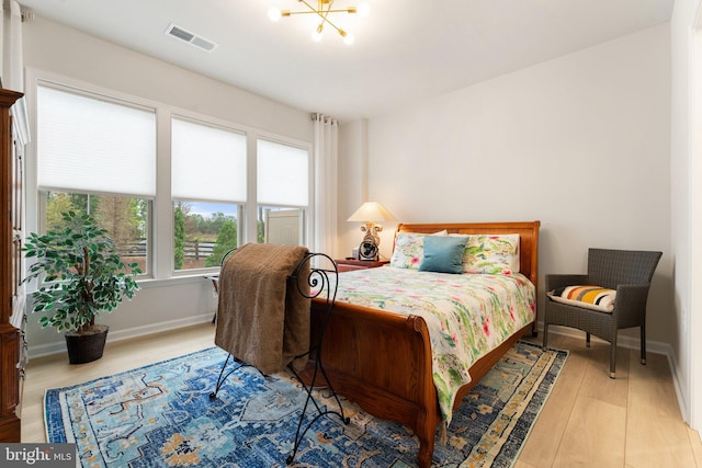 6411 Tulip Ter, Haymarket, VA 20169 - bedroom with wood finished floors, a chandelier, and baseboards