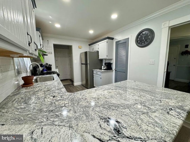 159 Harwich St, Browns Mills, NJ 08015 - kitchen with a sink, freestanding refrigerator, light stone countertops, crown molding, and dark wood finished floors