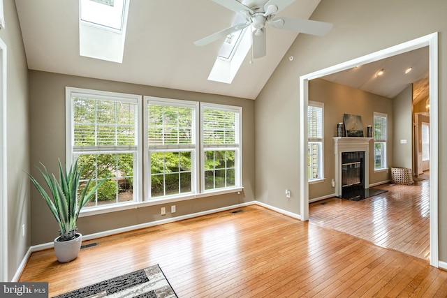 256 Silverbell Ct, West Chester, PA 19380 - unfurnished living room with a skylight, wood-type flooring, lofted ceiling, ceiling fan, and a glass covered fireplace