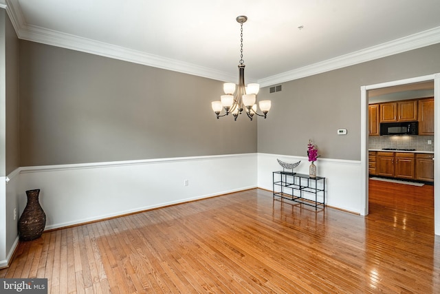 256 Silverbell Ct, West Chester, PA 19380 - spare room featuring light wood-type flooring, crown molding, a chandelier, and baseboards