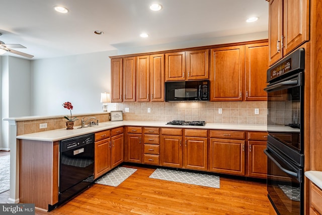 256 Silverbell Ct, West Chester, PA 19380 - kitchen with black appliances, a sink, a peninsula, brown cabinets, and recessed lighting