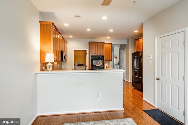 256 Silverbell Ct, West Chester, PA 19380 - kitchen featuring black appliances, a peninsula, light wood-type flooring, recessed lighting, and brown cabinets