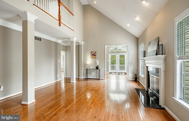 256 Silverbell Ct, West Chester, PA 19380 - unfurnished living room featuring decorative columns, a premium fireplace, wood-type flooring, a ceiling fan, and high vaulted ceiling