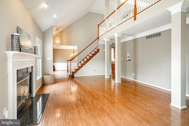 256 Silverbell Ct, West Chester, PA 19380 - unfurnished living room featuring high vaulted ceiling, hardwood / wood-style flooring, ornate columns, baseboards, and a premium fireplace