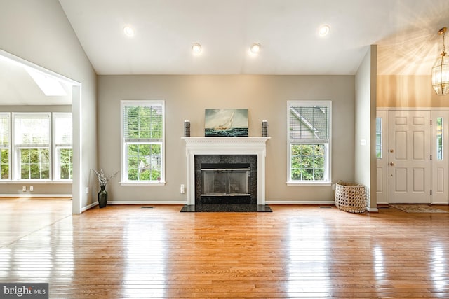 256 Silverbell Ct, West Chester, PA 19380 - unfurnished living room featuring hardwood / wood-style flooring, healthy amount of natural light, lofted ceiling, and a high end fireplace