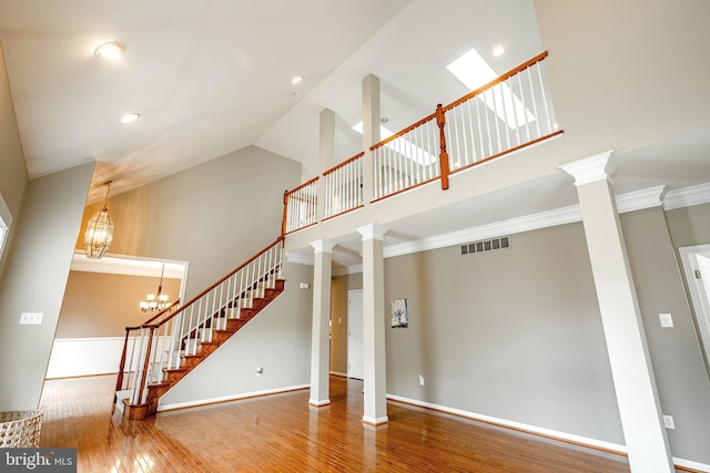 256 Silverbell Ct, West Chester, PA 19380 - unfurnished living room with high vaulted ceiling, stairs, wood finished floors, decorative columns, and baseboards