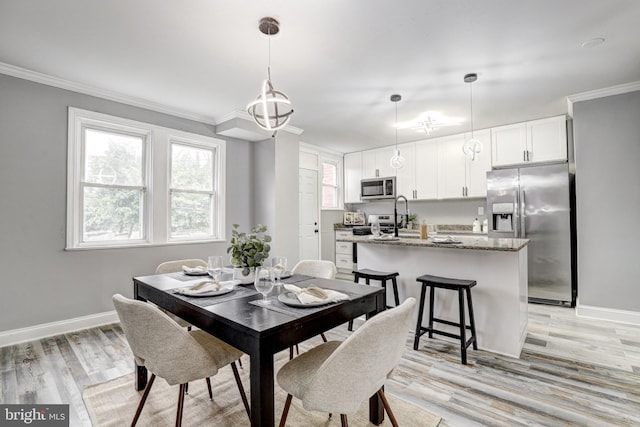 2503 W Forest Park Ave, Baltimore, MD 21215 - dining space with crown molding, baseboards, and light wood-style floors