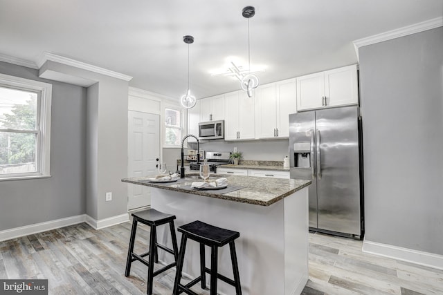 2503 W Forest Park Ave, Baltimore, MD 21215 - kitchen with appliances with stainless steel finishes, light wood finished floors, light stone countertops, baseboards, and white cabinets