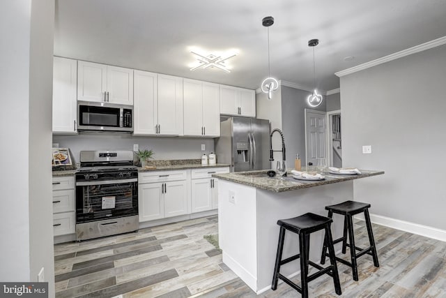 2503 W Forest Park Ave, Baltimore, MD 21215 - kitchen featuring appliances with stainless steel finishes, ornamental molding, white cabinetry, light stone counters, and light wood-style floors