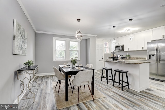 2503 W Forest Park Ave, Baltimore, MD 21215 - dining space with crown molding, light wood finished floors, and baseboards