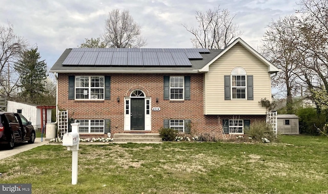 4914 Tecumseh St, College Park, MD 20740 - split foyer home featuring solar panels, a front yard, brick siding, and roof with shingles