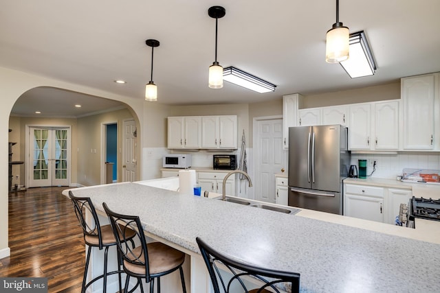 94 Eagle Ct, Woodstock, VA 22664 - kitchen featuring appliances with stainless steel finishes, arched walkways, a sink, backsplash, and white cabinets