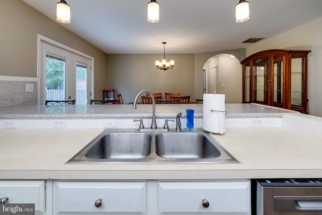 94 Eagle Ct, Woodstock, VA 22664 - kitchen featuring a sink, light countertops, arched walkways, white cabinetry, and a chandelier