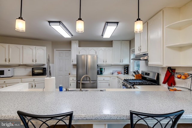 94 Eagle Ct, Woodstock, VA 22664 - kitchen featuring appliances with stainless steel finishes, under cabinet range hood, a peninsula, tasteful backsplash, and open shelves
