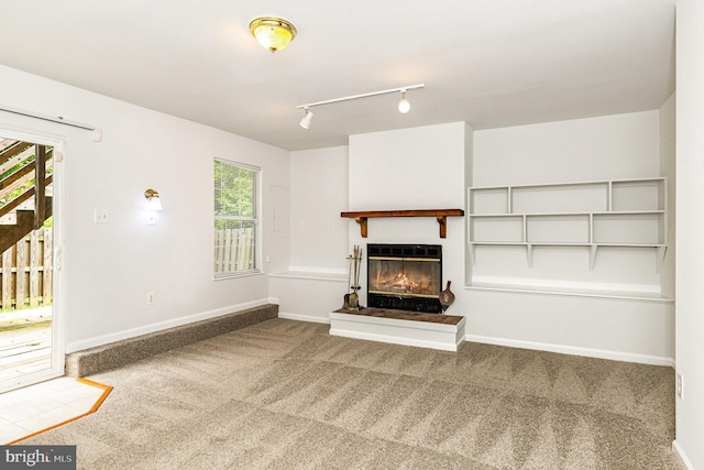 211 Westminster Ln Unit 119, Stafford, VA 22556 - unfurnished living room featuring carpet floors, a glass covered fireplace, rail lighting, and baseboards
