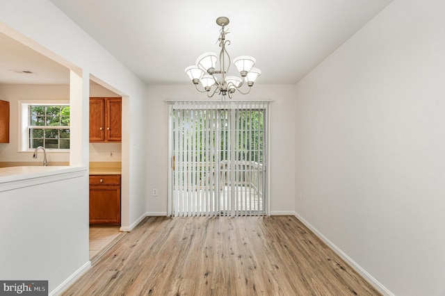 211 Westminster Ln Unit 119, Stafford, VA 22556 - unfurnished dining area featuring light wood finished floors, a chandelier, and baseboards