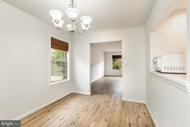 211 Westminster Ln Unit 119, Stafford, VA 22556 - empty room with a chandelier, healthy amount of natural light, light wood-style flooring, and baseboards