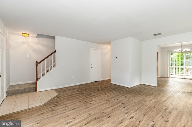 211 Westminster Ln Unit 119, Stafford, VA 22556 - unfurnished living room with stairway, a chandelier, wood finished floors, and baseboards