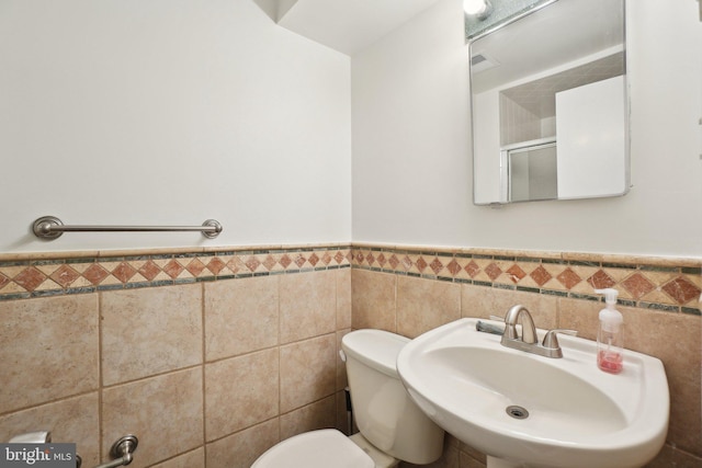 12834 Littleton St, Silver Spring, MD 20906 - bathroom with a sink, toilet, wainscoting, tile walls, and a shower with shower door