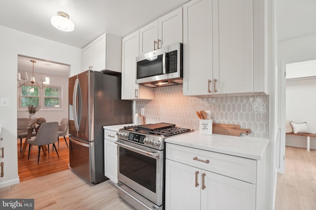 12834 Littleton St, Silver Spring, MD 20906 - kitchen with stainless steel appliances, light wood-style flooring, white cabinetry, and decorative backsplash
