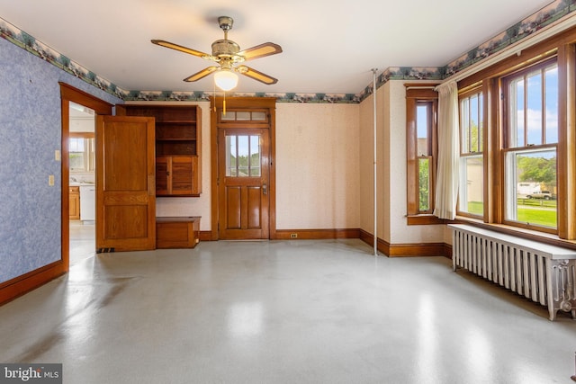 837 Broadway, Hanover, PA 17331 - unfurnished room with radiator heating unit, ceiling fan, baseboards, wallpapered walls, and concrete flooring