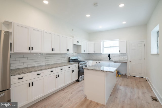 1606 Wharton St, Philadelphia, PA 19146 - kitchen with stainless steel appliances, a sink, tasteful backsplash, light wood finished floors, and recessed lighting