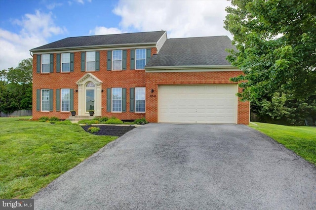 10526 Jasper Dr S, Greencastle, PA 17225 - colonial house featuring asphalt driveway, an attached garage, brick siding, and a front lawn