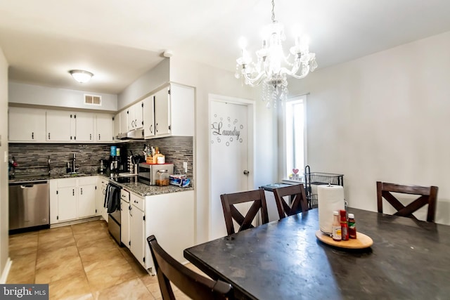 4548 Conwell Dr, Annandale, VA 22003 - kitchen featuring appliances with stainless steel finishes, backsplash, light tile patterned floors, white cabinetry, and a chandelier