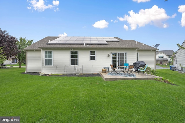 1009 Rosebud St, Reading, PA 19605 - rear view of house with a patio area, roof mounted solar panels, a lawn, and roof with shingles