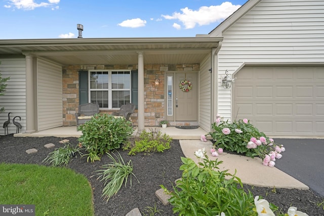 1009 Rosebud St, Reading, PA 19605 - property entrance featuring covered porch, stone siding, and an attached garage