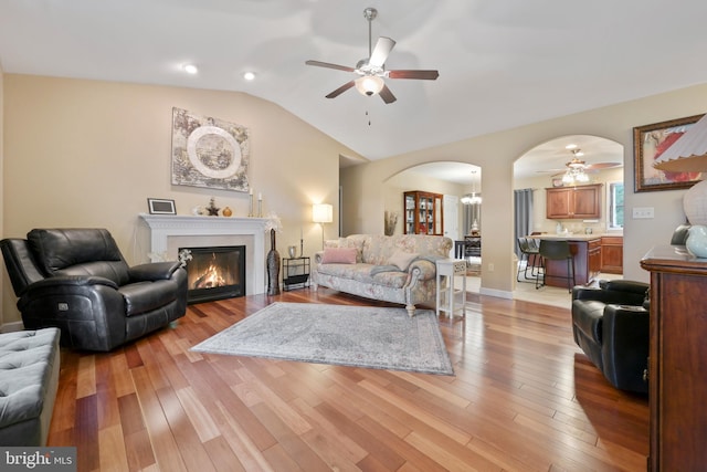 1009 Rosebud St, Reading, PA 19605 - living room with a ceiling fan, lofted ceiling, arched walkways, light wood-type flooring, and a glass covered fireplace