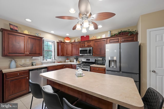 1009 Rosebud St, Reading, PA 19605 - kitchen featuring stainless steel appliances, a kitchen bar, light countertops, a ceiling fan, and a center island