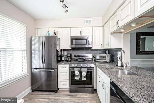 2305A Yarmouth Ln, Mount Laurel, NJ 08054 - kitchen featuring appliances with stainless steel finishes, a sink, white cabinetry, and dark stone countertops