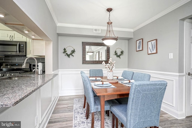 2305A Yarmouth Ln, Mount Laurel, NJ 08054 - dining area featuring crown molding, light wood-type flooring, a wainscoted wall, and a decorative wall