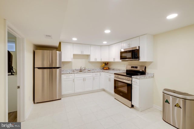 3312 Clay St, Silver Spring, MD 20902 - kitchen featuring stainless steel appliances, a sink, white cabinets, recessed lighting, and light stone countertops